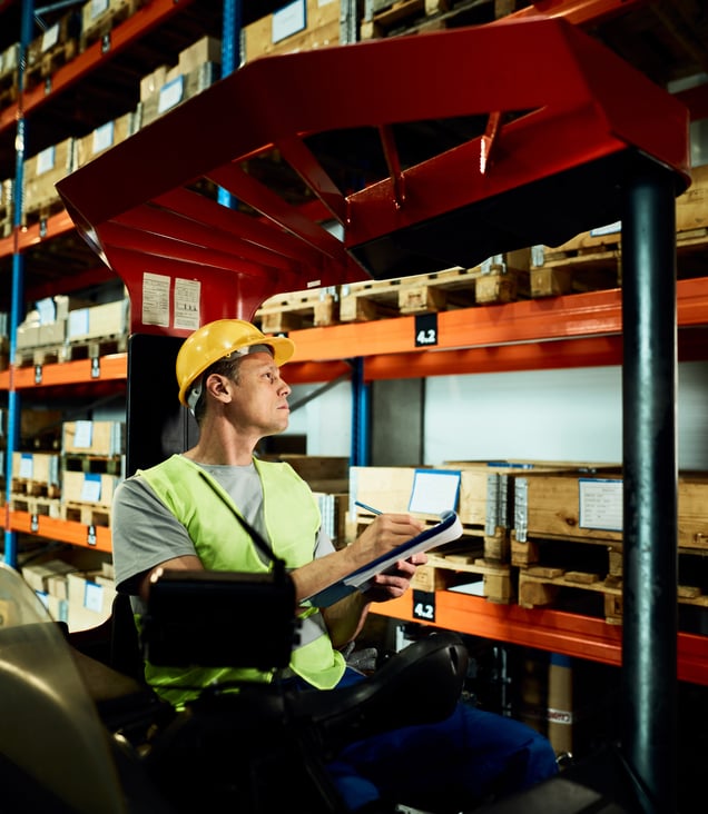 forklift-operator-taking-notes-while-examining-stock-packages-2