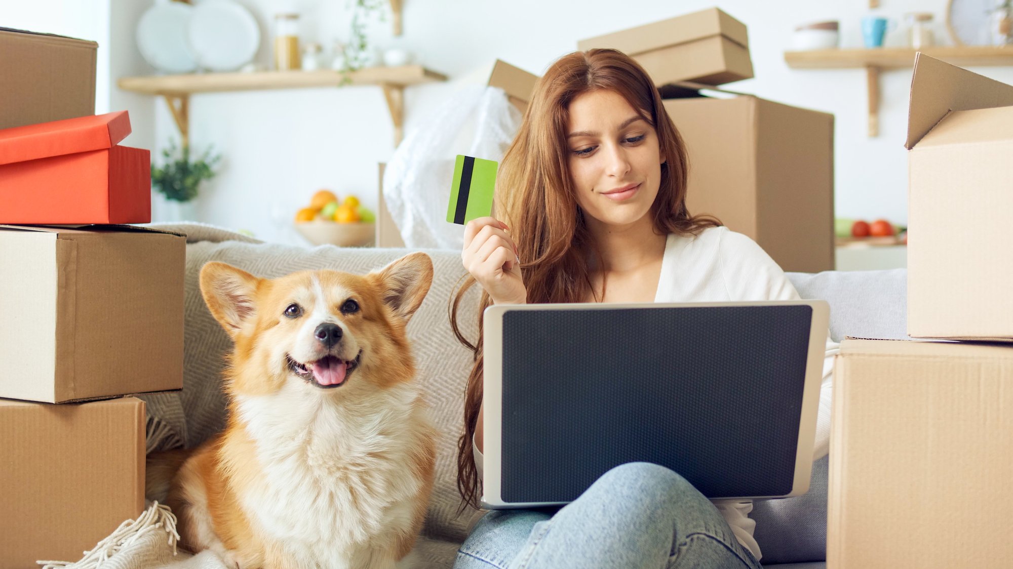 woman-uses-laptop-online-shopping-home-purchase-confirmation-by-internet-binding-card-online-shopping-woman-sitting-couch-with-cute-dog-while-online-shopping