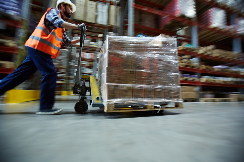 A man pushing cargo in a facility